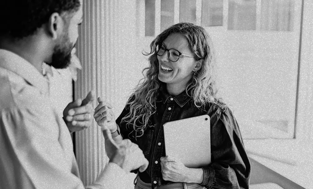 woman holding ipad speaking to a man