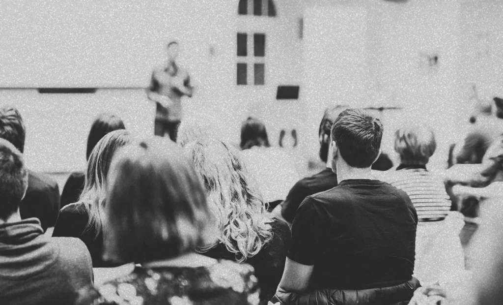 man speaking in front of a group of people