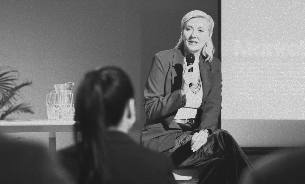 woman seated and speaking to group