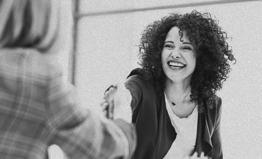 two women in work attire shaking hands
